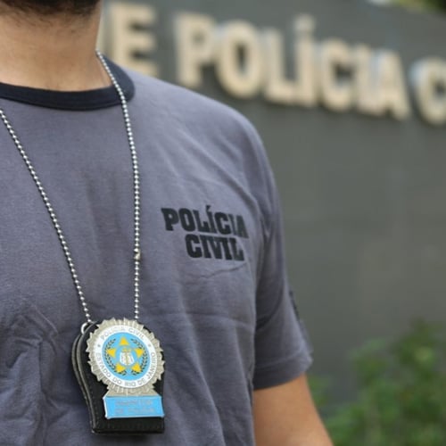 Policial civil do Rio de Janeiro usa distintivo em frente à sede da corporação