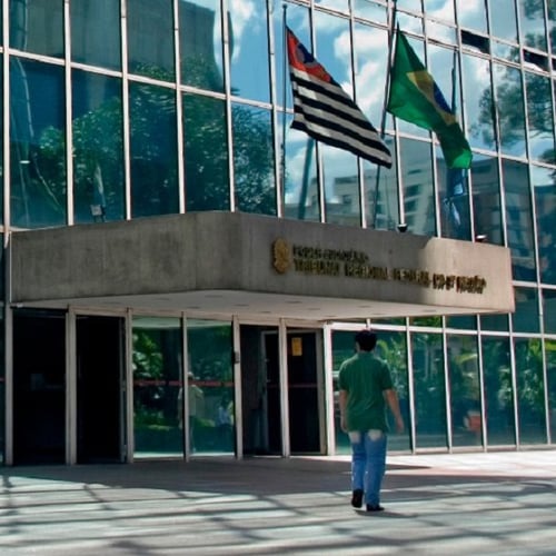 Homem caminhando em frente à sede do TRF3 (Foto: Reprodução/Facebook TRF3)